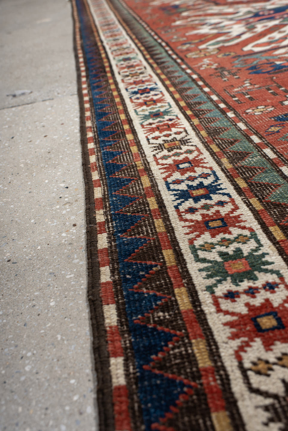 5' x 8' one-of-a-kind handmade antique Kazak medium size rug. Color palette: rust, ivory, navy, sage, gold, crimson, rose