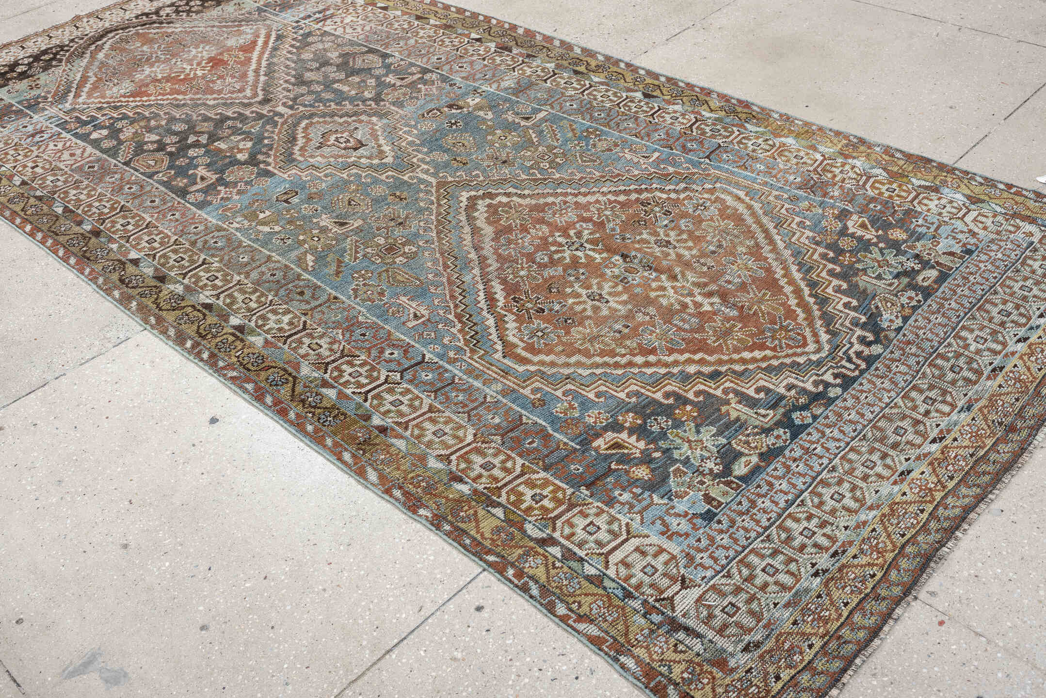 5' x 10' one-of-a-kind handmade vintage Shiraz runner rug. Color palette: sky blue, rust, ivory, brown, camel, charcoal