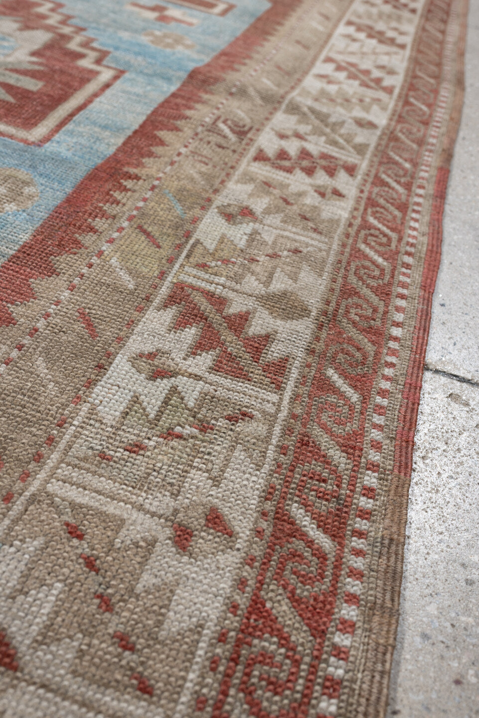 6' x 4' one-of-a-kind handmade antique Caucasian rug. Color palette: terracotta, ivory, sky blue, taupe, camel, brown