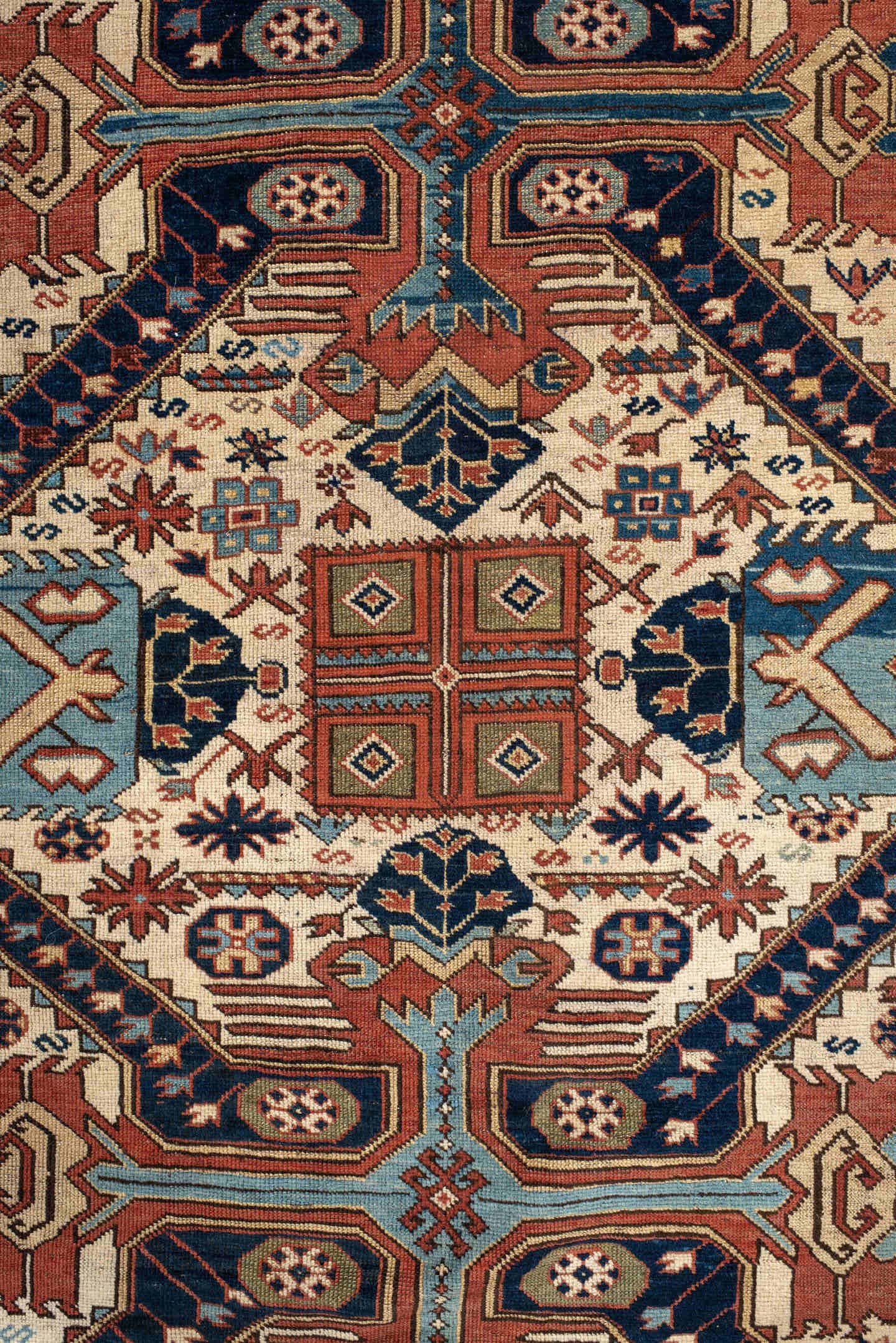 4' x 11' one-of-a-kind handmade antique Caucasian runner rug. Color palette: ivory, indigo, rust, sky blue, navy, camel