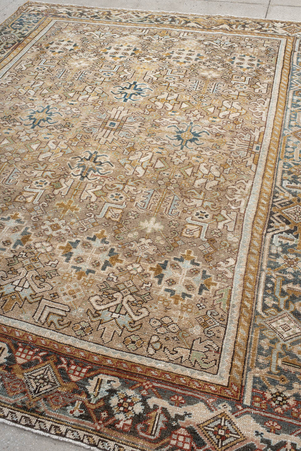 7' x 9' one-of-a-kind handmade antique Heriz rug. Color palette: taupe, ivory, faded indigo, camel, rust, charcoal, beige