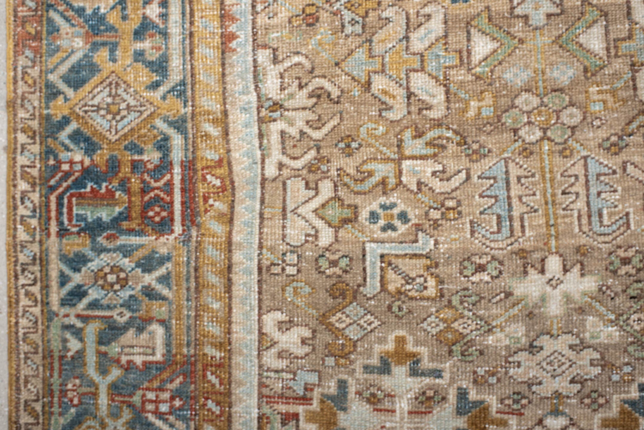 7' x 9' one-of-a-kind handmade antique Heriz rug. Color palette: taupe, ivory, faded indigo, camel, rust, charcoal, beige