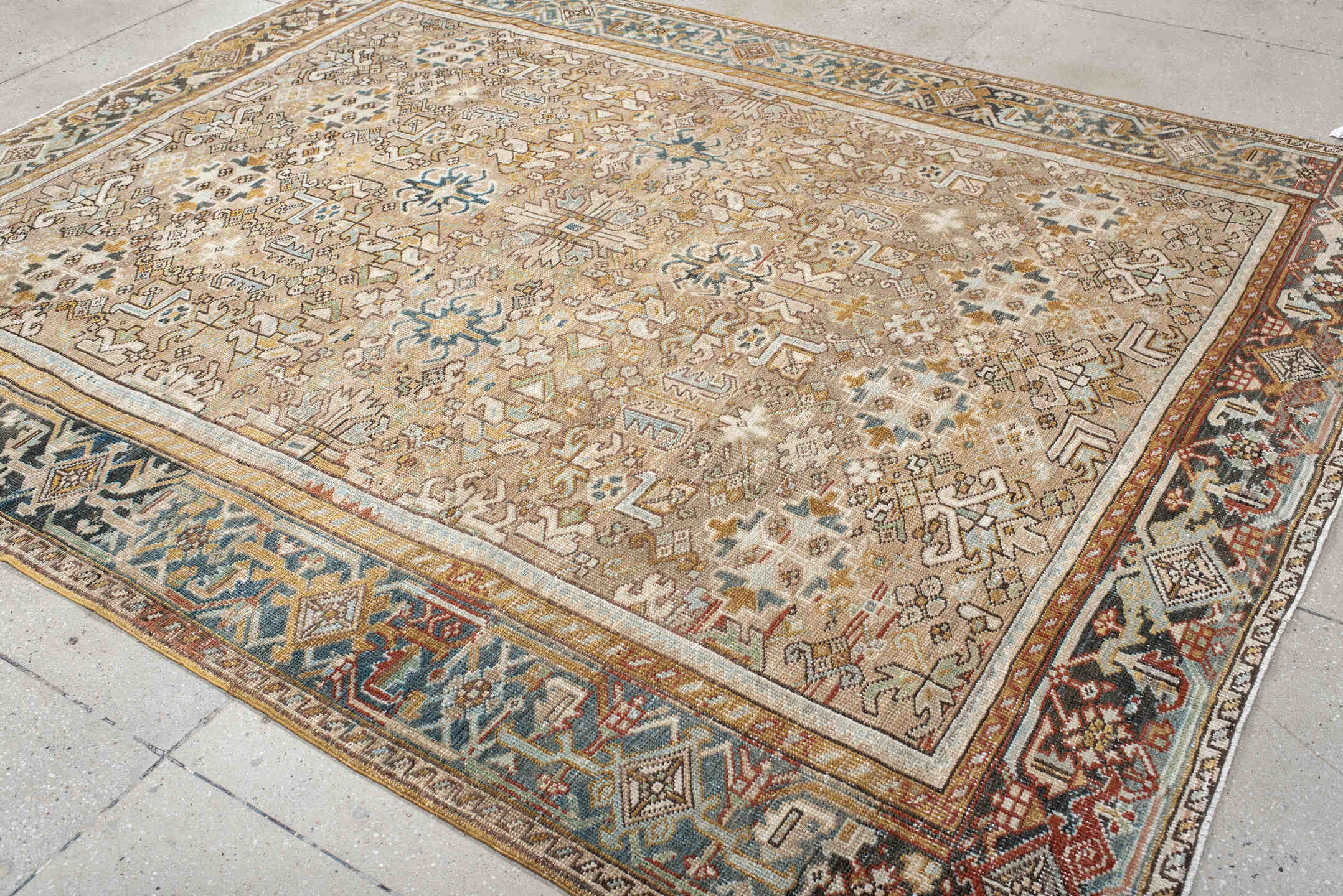7' x 9' one-of-a-kind handmade antique Heriz rug. Color palette: taupe, ivory, faded indigo, camel, rust, charcoal, beige
