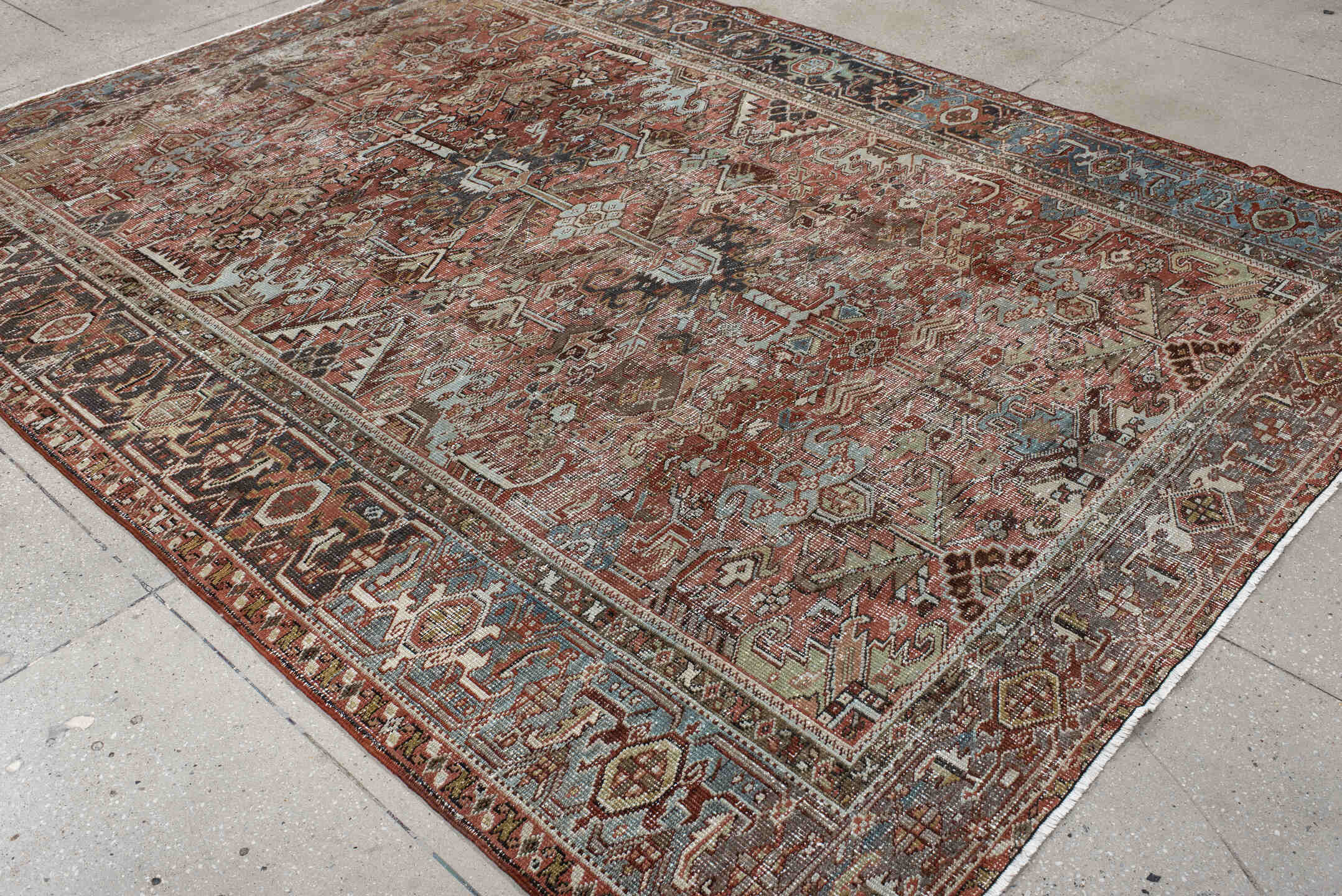 7' x 9' one-of-a-kind handmade antique Heriz rug. Color palette: rust, ivory, sky blue, charcoal, taupe, camel, brown