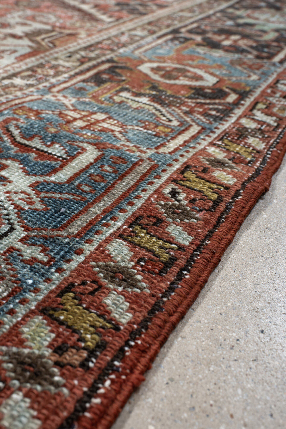 7' x 9' one-of-a-kind handmade antique Heriz rug. Color palette: rust, ivory, sky blue, charcoal, taupe, camel, brown