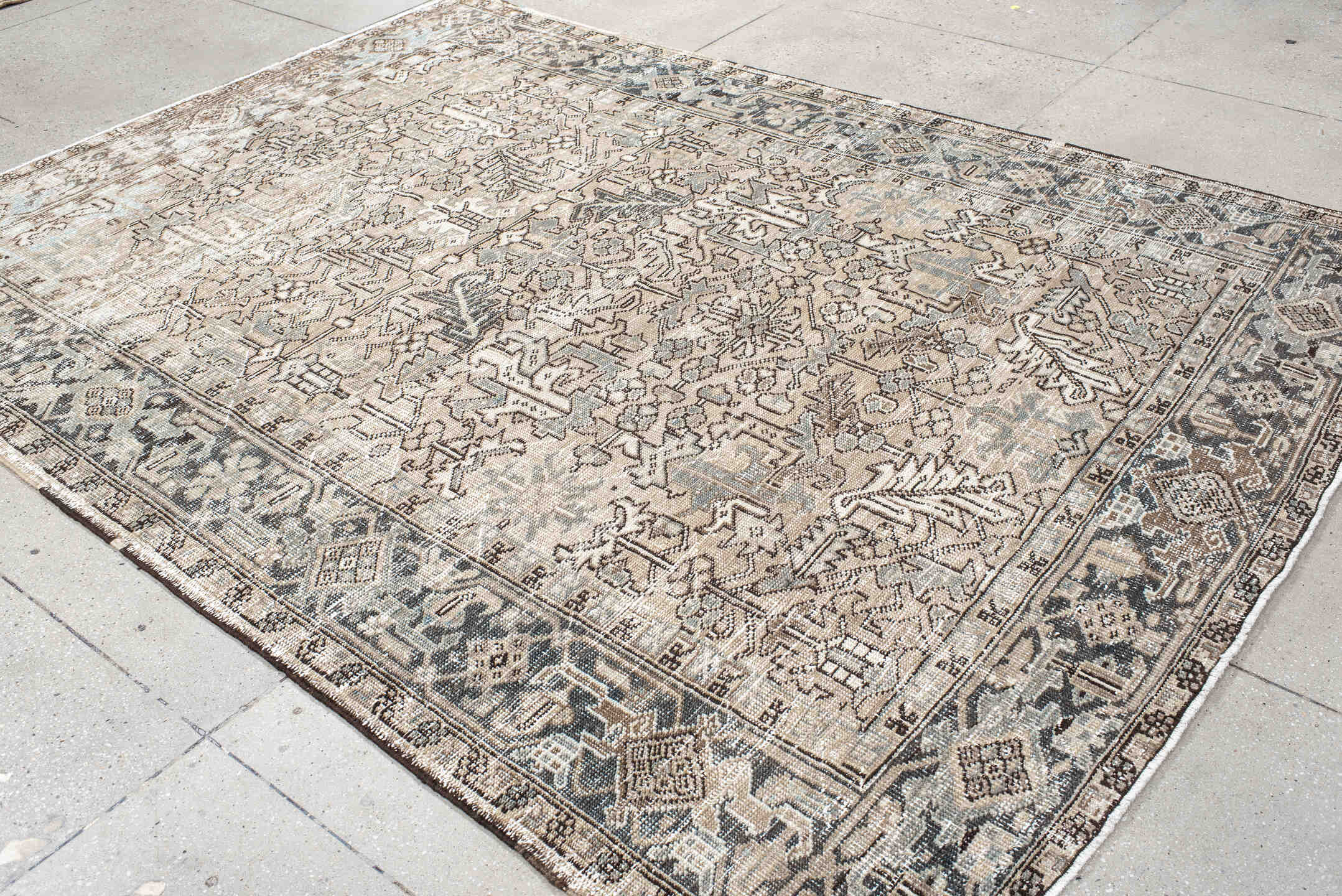 7' x 9' one-of-a-kind handmade antique Heriz rug. Color palette: ivory, taupe, slate, charcoal, camel, pale blue, brown