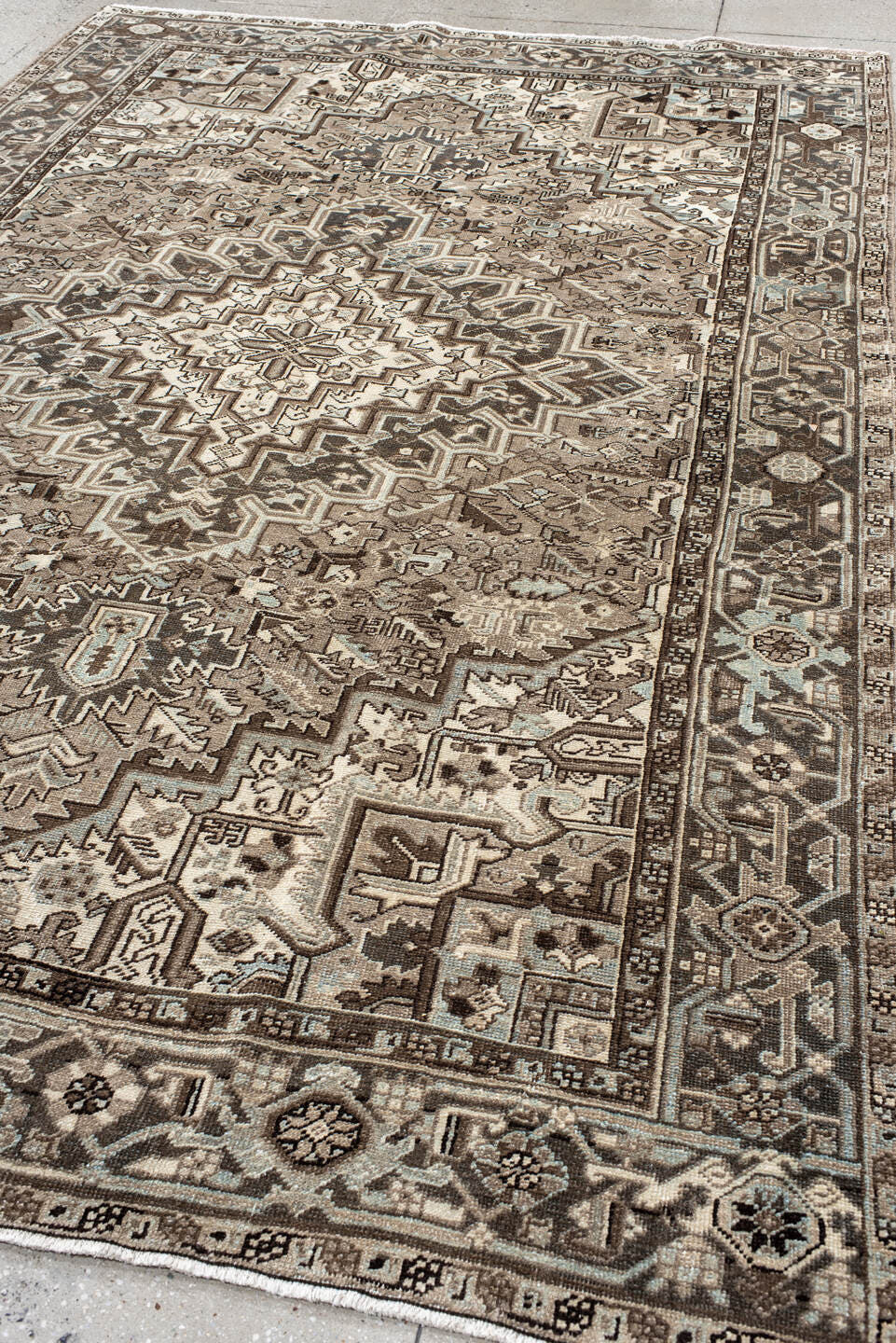 7' x 11' one-of-a-kind handmade antique Heriz large size rug. Color palette: taupe, brown, ivory, charcoal, pale blue, camel