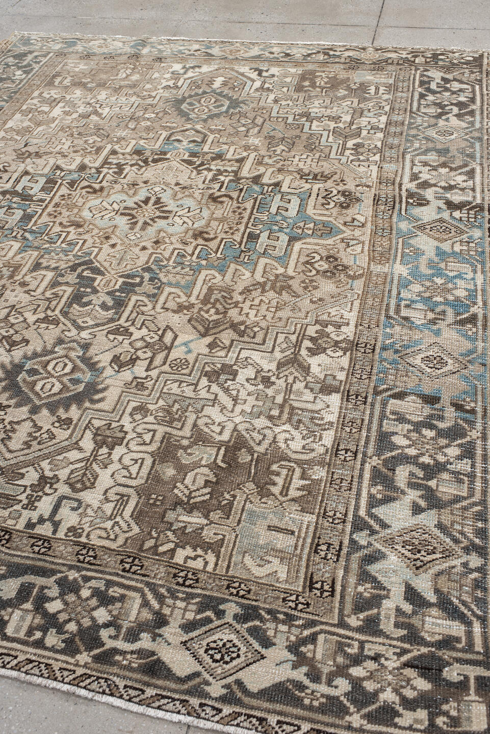 7' x 9' one-of-a-kind handmade antique Heriz rug. Color palette: ivory, taupe, charcoal, beige, sky blue, brown, gray, black