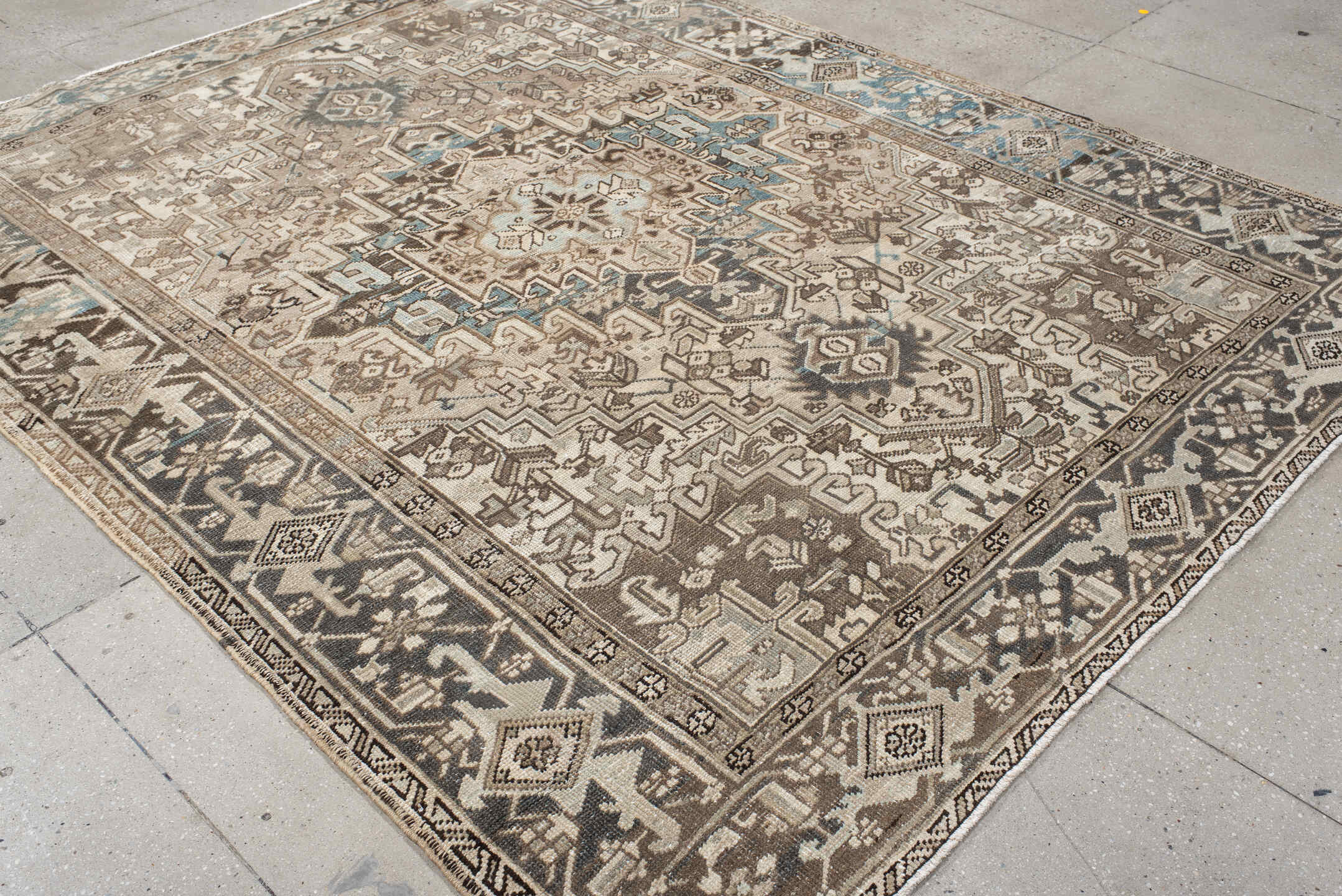 7' x 9' one-of-a-kind handmade antique Heriz rug. Color palette: ivory, taupe, charcoal, beige, sky blue, brown, gray, black