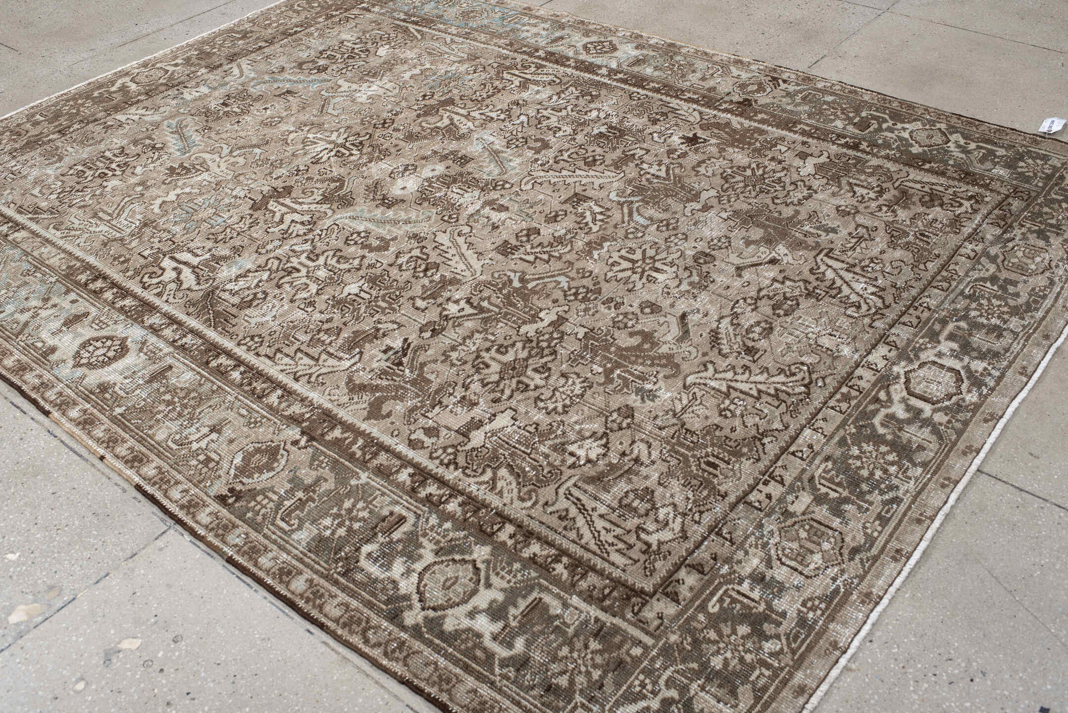 7' x 9' one-of-a-kind handmade antique Heriz rug. Color palette: taupe, brown, ivory, beige, pale blue, camel, gray