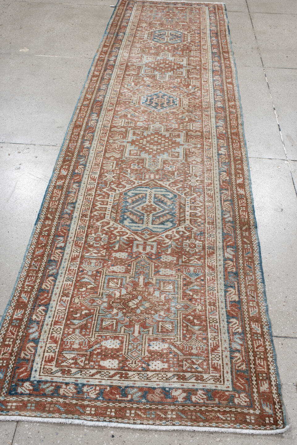 3' x 11' one-of-a-kind handmade antique Karaje runner rug. Color palette: terra cotta, ivory, sky blue, rust, camel, slate