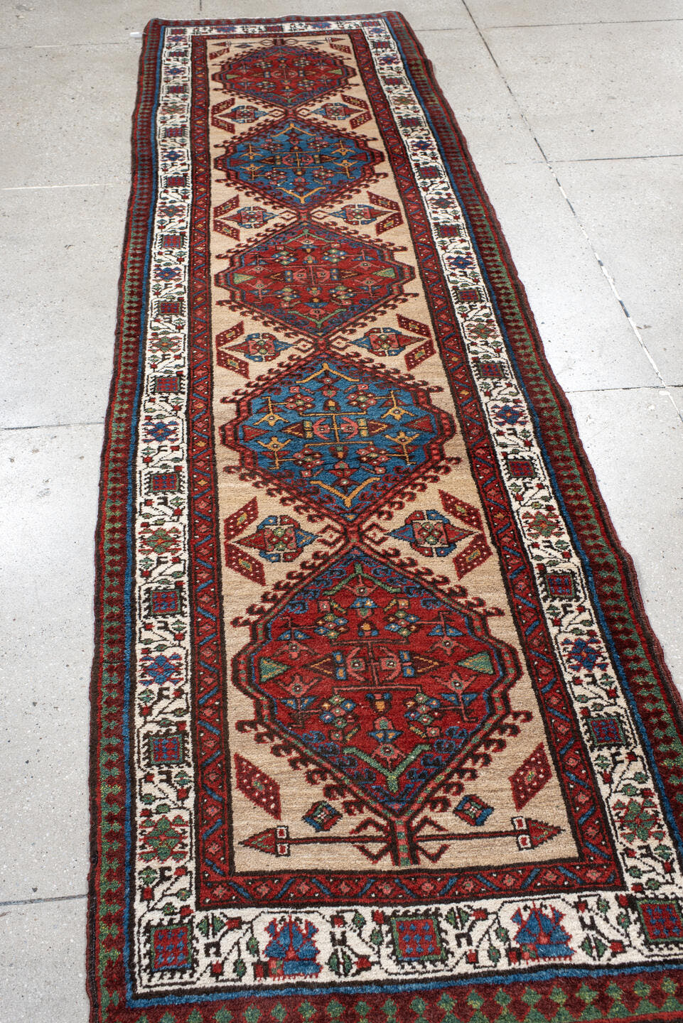 3' x 10' one-of-a-kind handmade antique Sarab runner rug. Color palette: ivory, rust, sky blue, crimson, navy, teal, brown