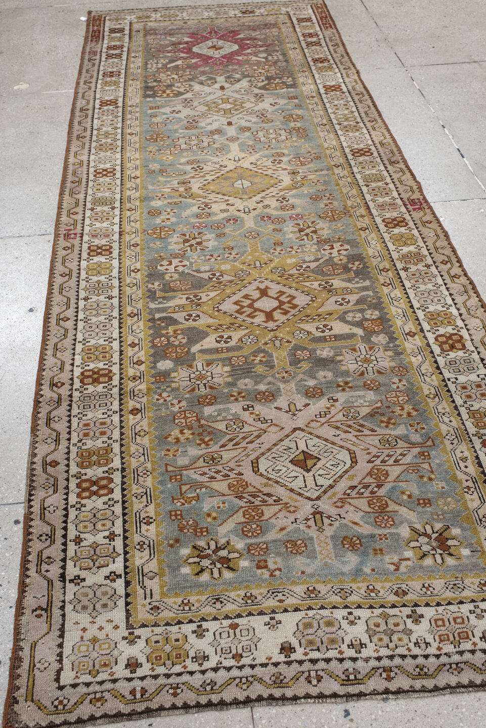 3' x 10' one-of-a-kind handmade antique Caucasian runner rug. Color palette: ivory, pale blue, taupe, rose, rust, gold, sage