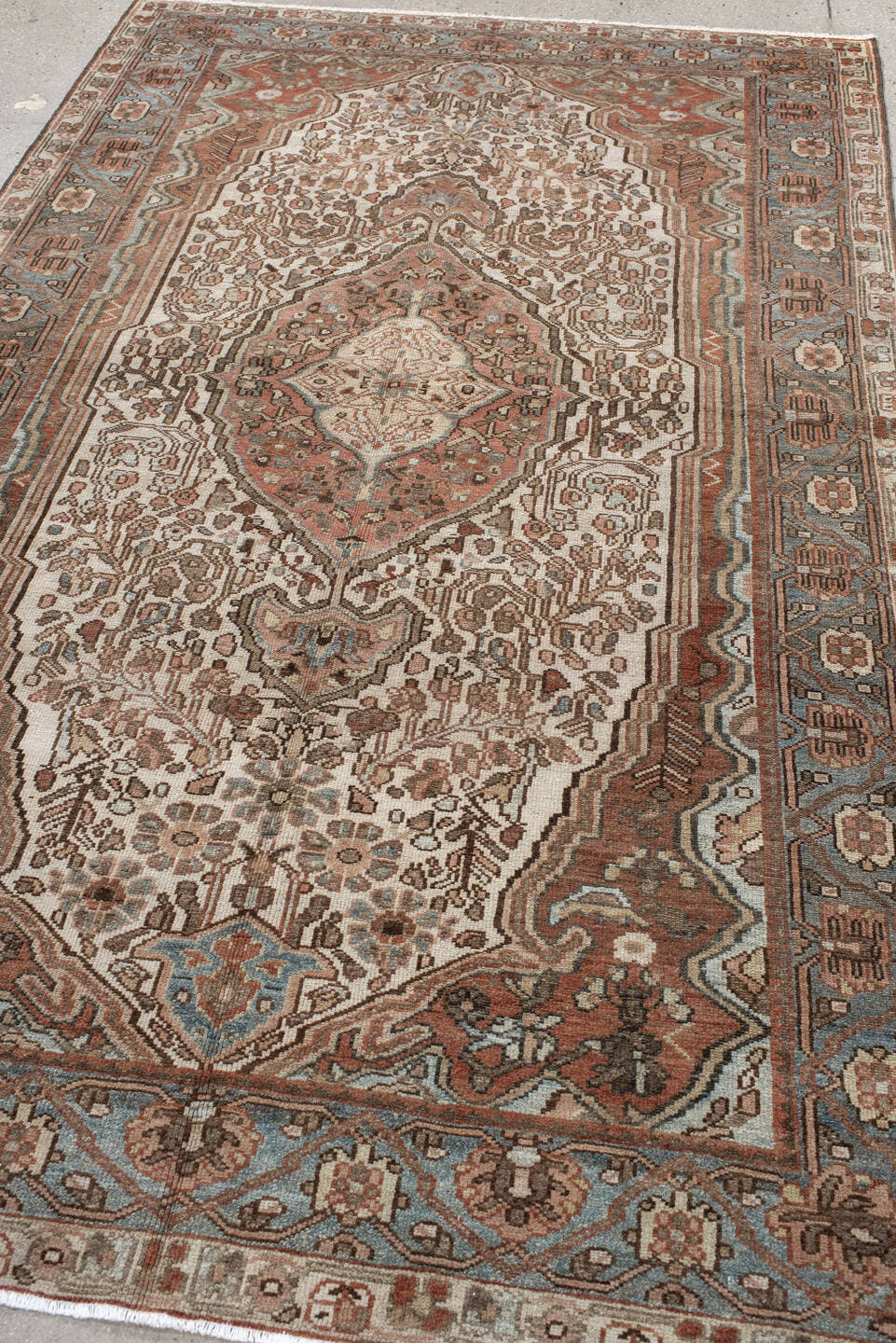 5' x 8' one-of-a-kind handmade antique Baktiary medium size rug. Color palette: ivory, dusty blue, rust, taupe, brown