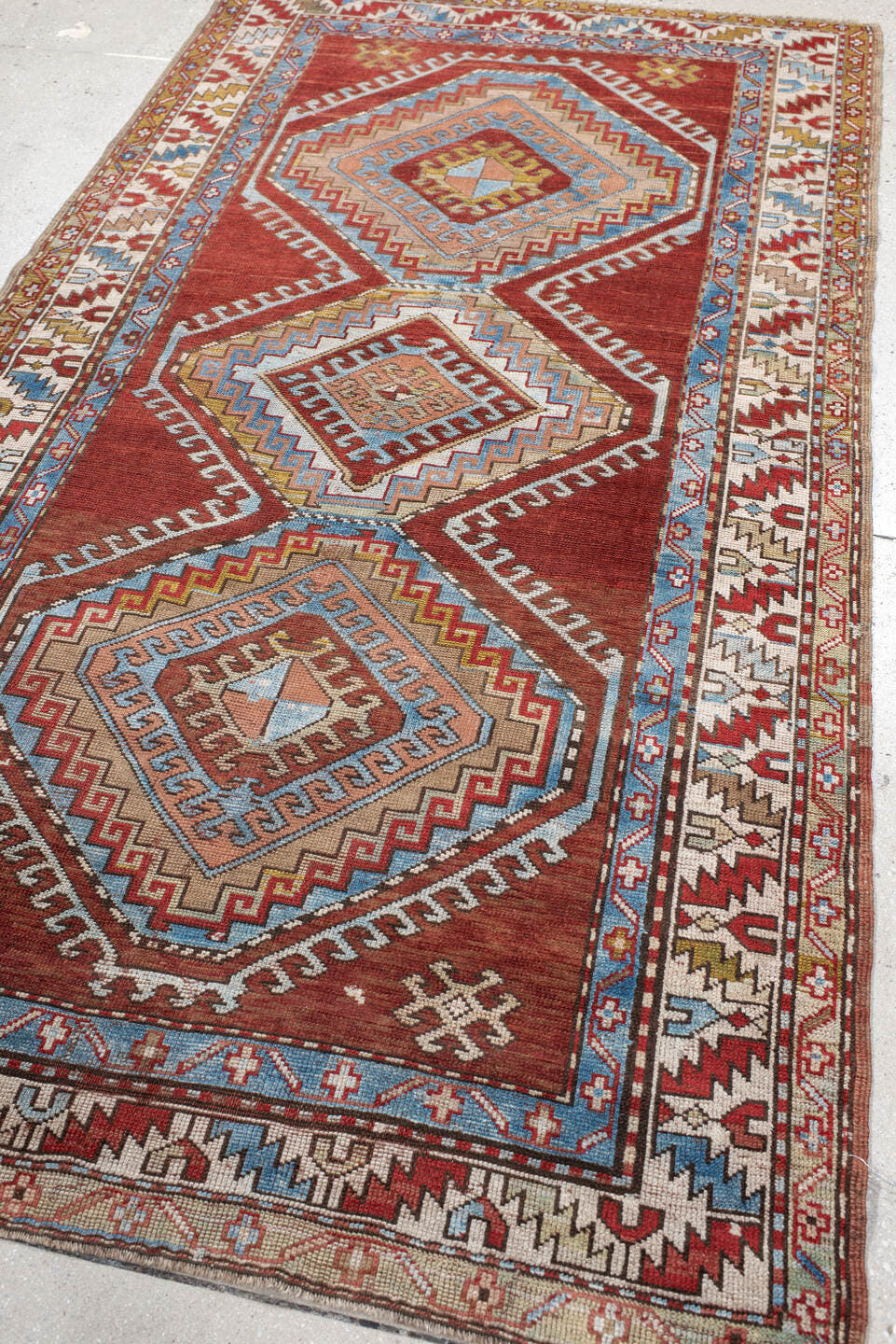 4' x 7' one-of-a-kind handmade vintage Kazak rug. Color palette: rust, ivory, sky blue, brick red, camel, taupe, gold, brown