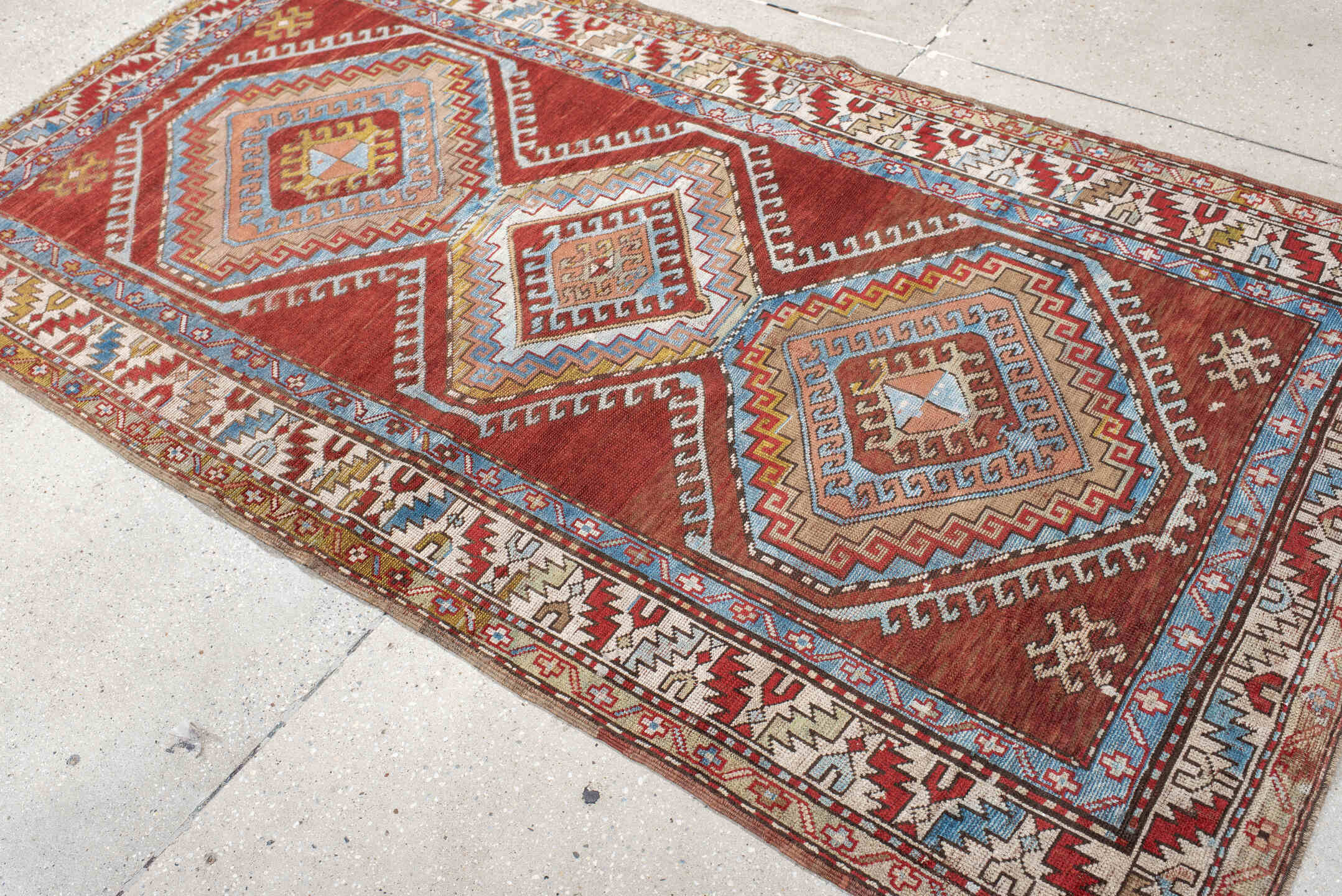 4' x 7' one-of-a-kind handmade vintage Kazak rug. Color palette: rust, ivory, sky blue, brick red, camel, taupe, gold, brown