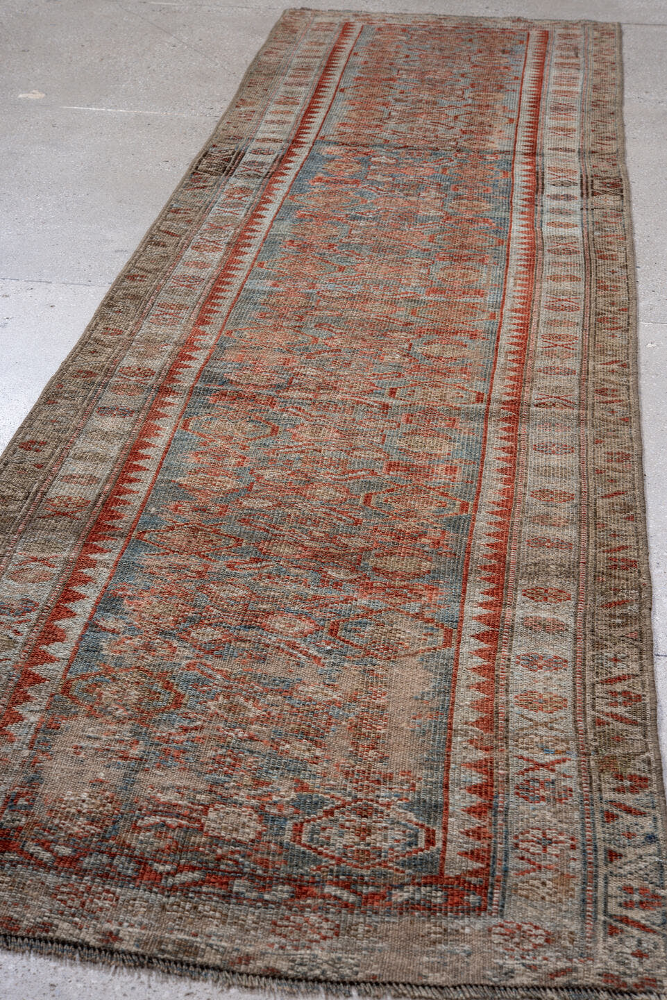 3' x 11' one-of-a-kind handmade antique Kurd runner rug. Color palette: ivory, rust, blue, taupe, brown, charcoal
