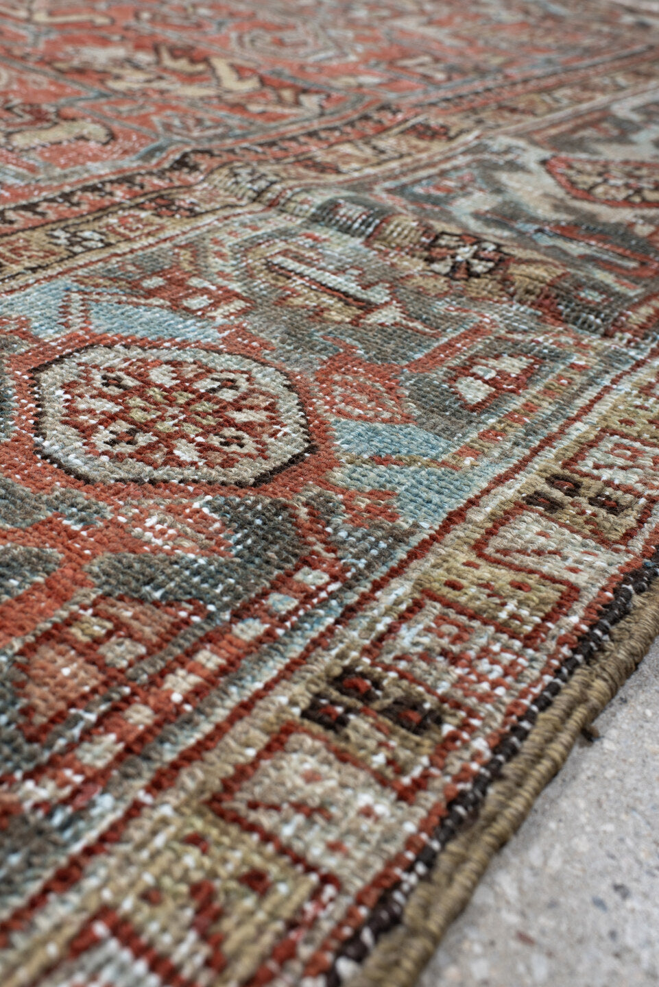 7' x 9' one-of-a-kind handmade antique Heriz large size rug. Color palette: terra cotta, ivory, slate, charcoal, rust, camel