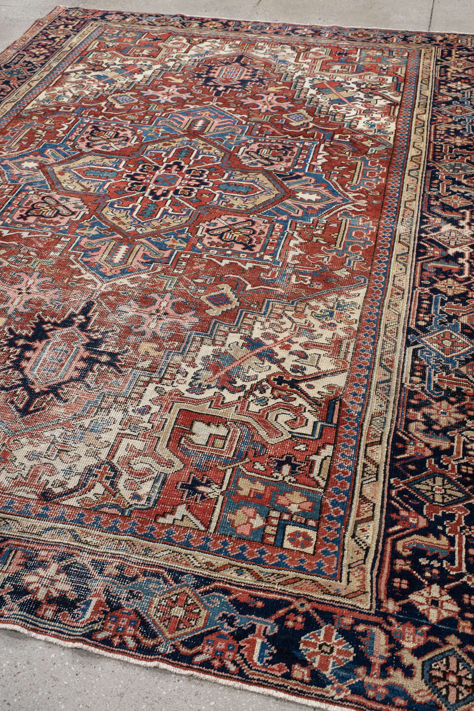 7' x 10' one-of-a-kind handmade antique Heriz large size rug. Color palette: rust, ivory, navy, sky_blue, brick, coral
