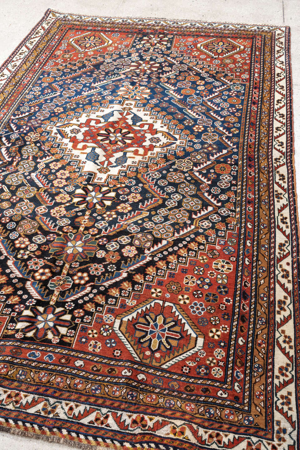4' x 8' one-of-a-kind handmade vintage Shirvan medium size rug. Color palette: rust, navy, ivory, camel, saffron, indigo