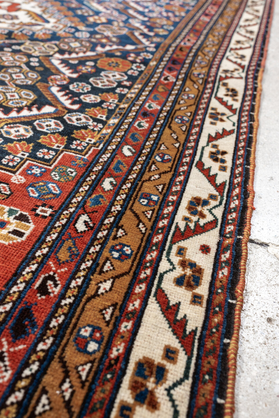4' x 8' one-of-a-kind handmade vintage Shirvan medium size rug. Color palette: rust, navy, ivory, camel, saffron, indigo