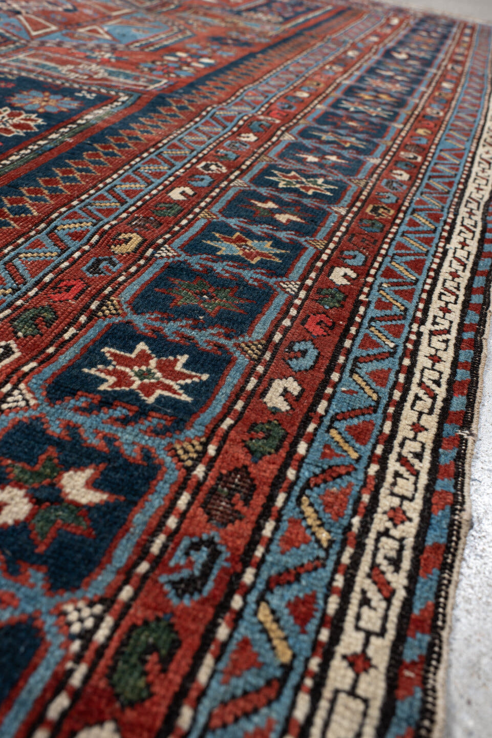4' x 8' one-of-a-kind handmade vintage Shirvan rug. Color palette: rust, navy, sky blue, ivory, terra cotta, slate, cream