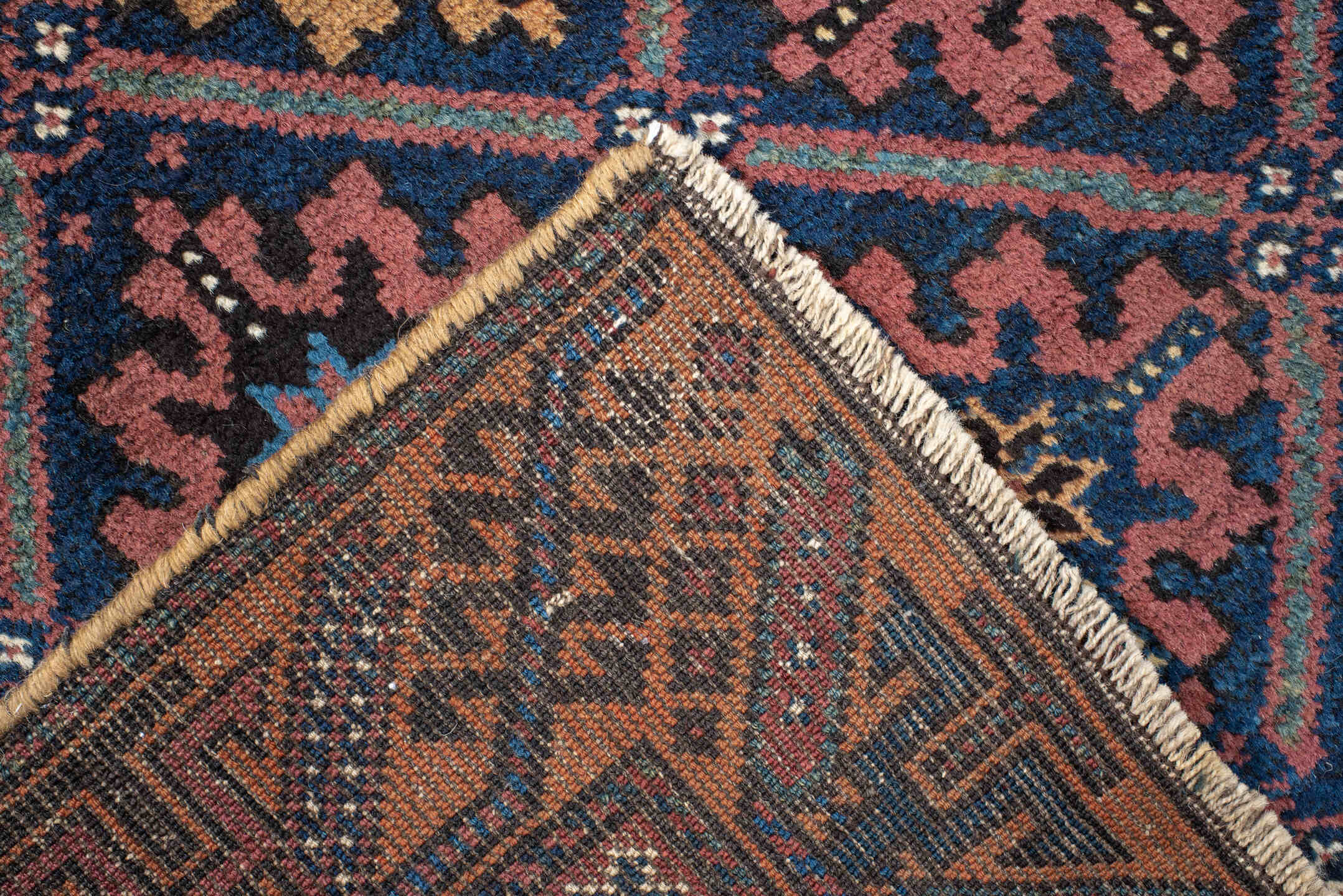 2' x 4' one-of-a-kind handmade vintage Belouch small size rug. Color palette: navy, camel, rust, indigo, gold, rose, ivory