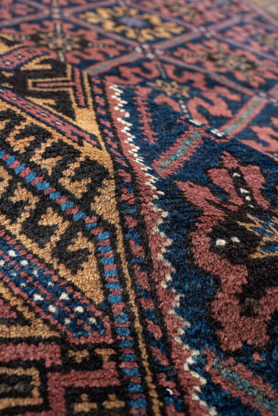 2' x 4' one-of-a-kind handmade vintage Belouch small size rug. Color palette: navy, camel, rust, indigo, gold, rose, ivory