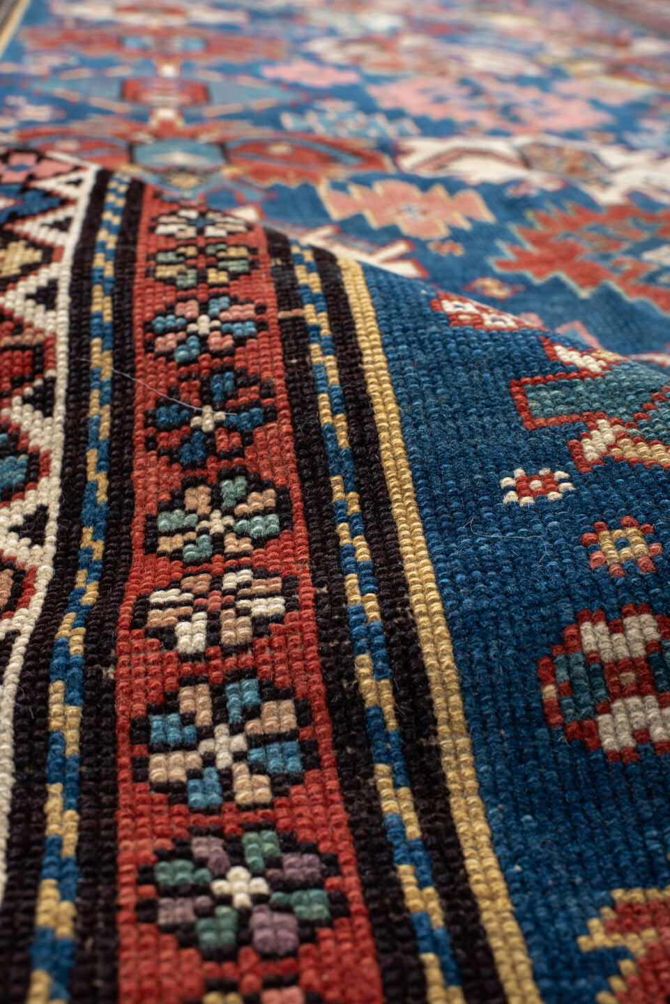 4' x 11' one-of-a-kind handmade vintage Caucasian runner rug. Color palette: arapawa, black, blue, brown, gray