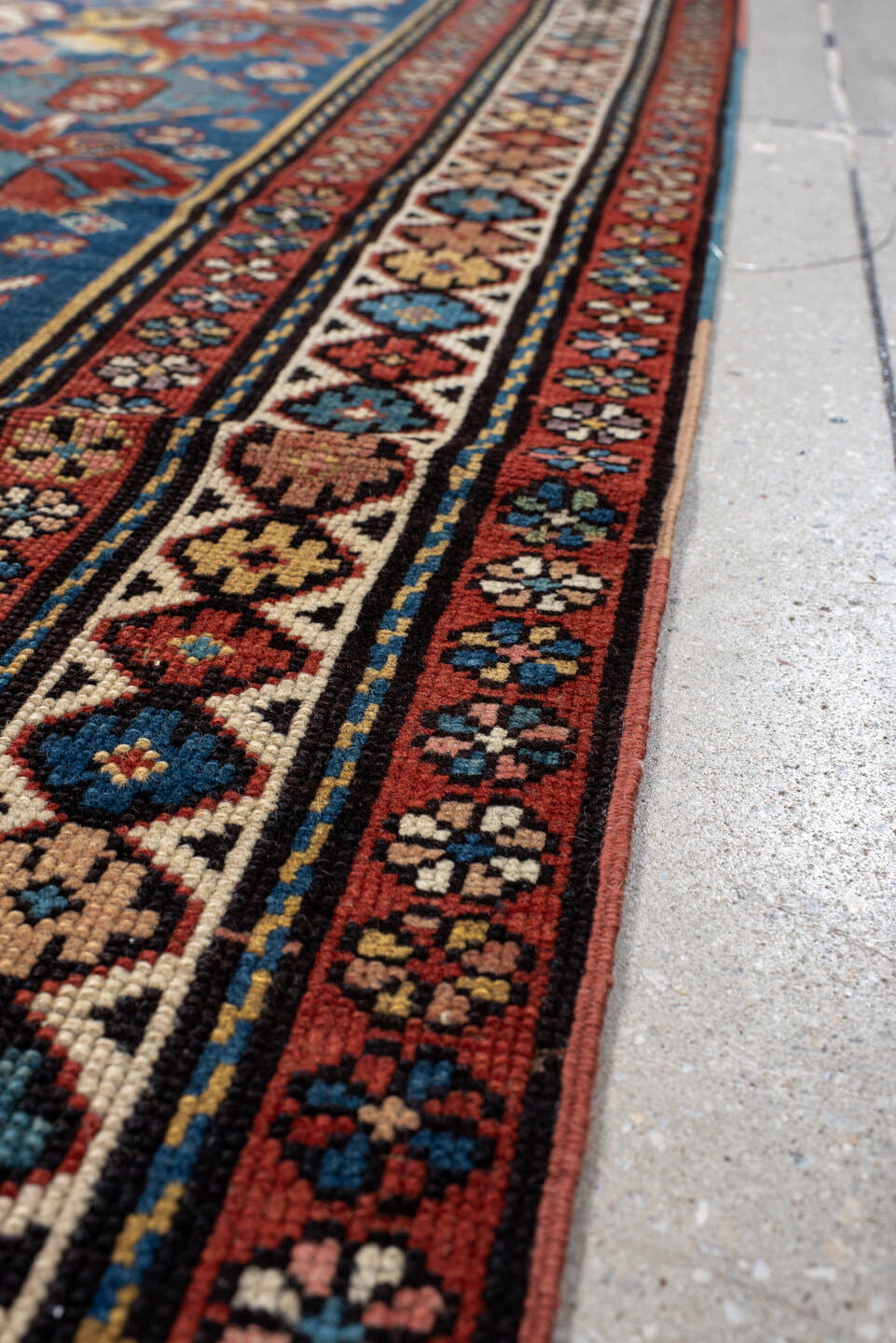 4' x 11' one-of-a-kind handmade vintage Caucasian runner rug. Color palette: blue, rust, ivory, indigo, terra cotta, camel