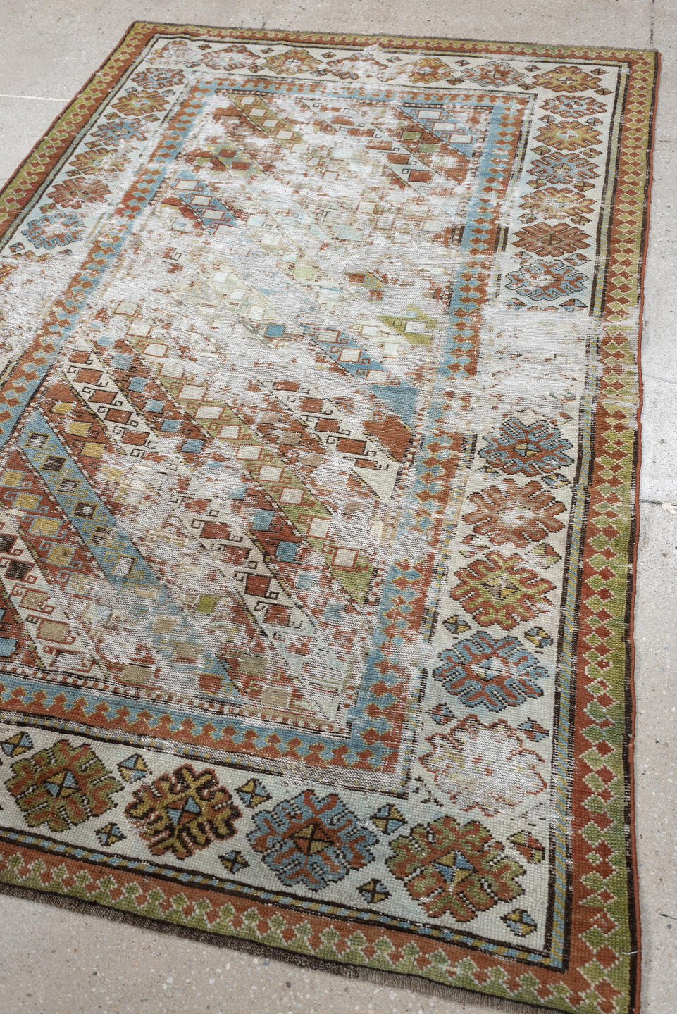 4' x 6' one-of-a-kind handmade antique Caucasian rug. Color palette: ivory, rust, sky blue, olive, camel, taupe, brown