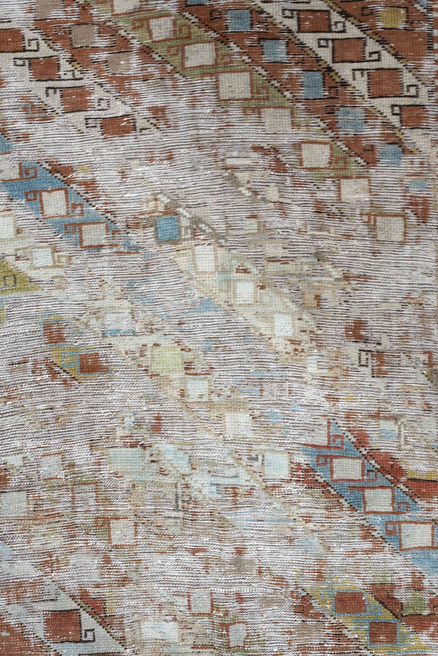 4' x 6' one-of-a-kind handmade antique Caucasian rug. Color palette: ivory, rust, sky blue, olive, camel, taupe, brown