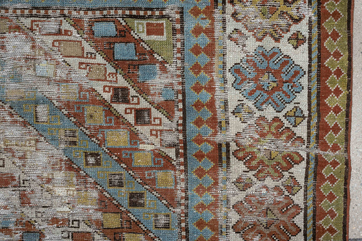 4' x 6' one-of-a-kind handmade antique Caucasian rug. Color palette: ivory, rust, sky blue, olive, camel, taupe, brown