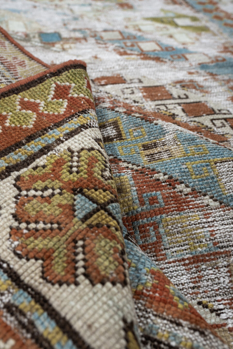 4' x 6' one-of-a-kind handmade antique Caucasian rug. Color palette: ivory, rust, sky blue, olive, camel, taupe, brown