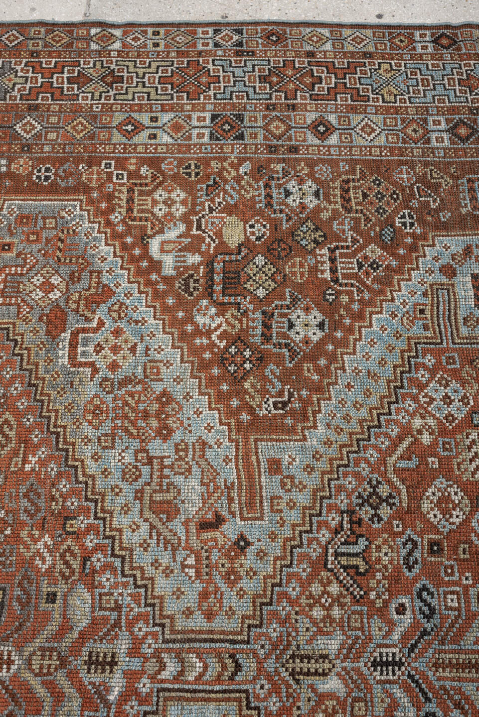 7' x 9' one-of-a-kind handmade antique Shiraz rug. Color palette: rust, pale blue gray, ivory, charcoal, terracotta, camel