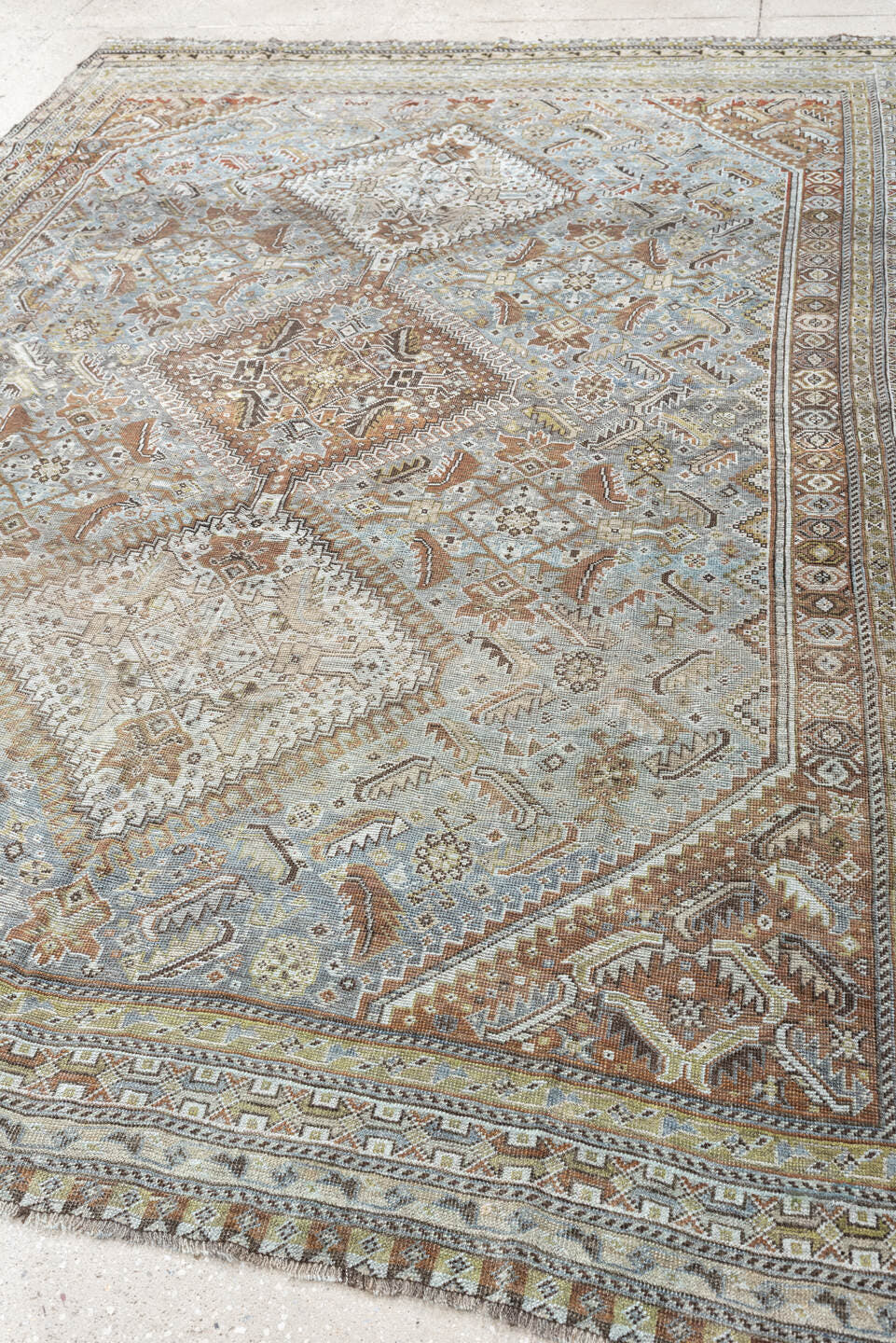 6' x 9' one-of-a-kind handmade antique Shiraz rug. Color palette: light blue, ivory, taupe, rust, brown, gold, camel