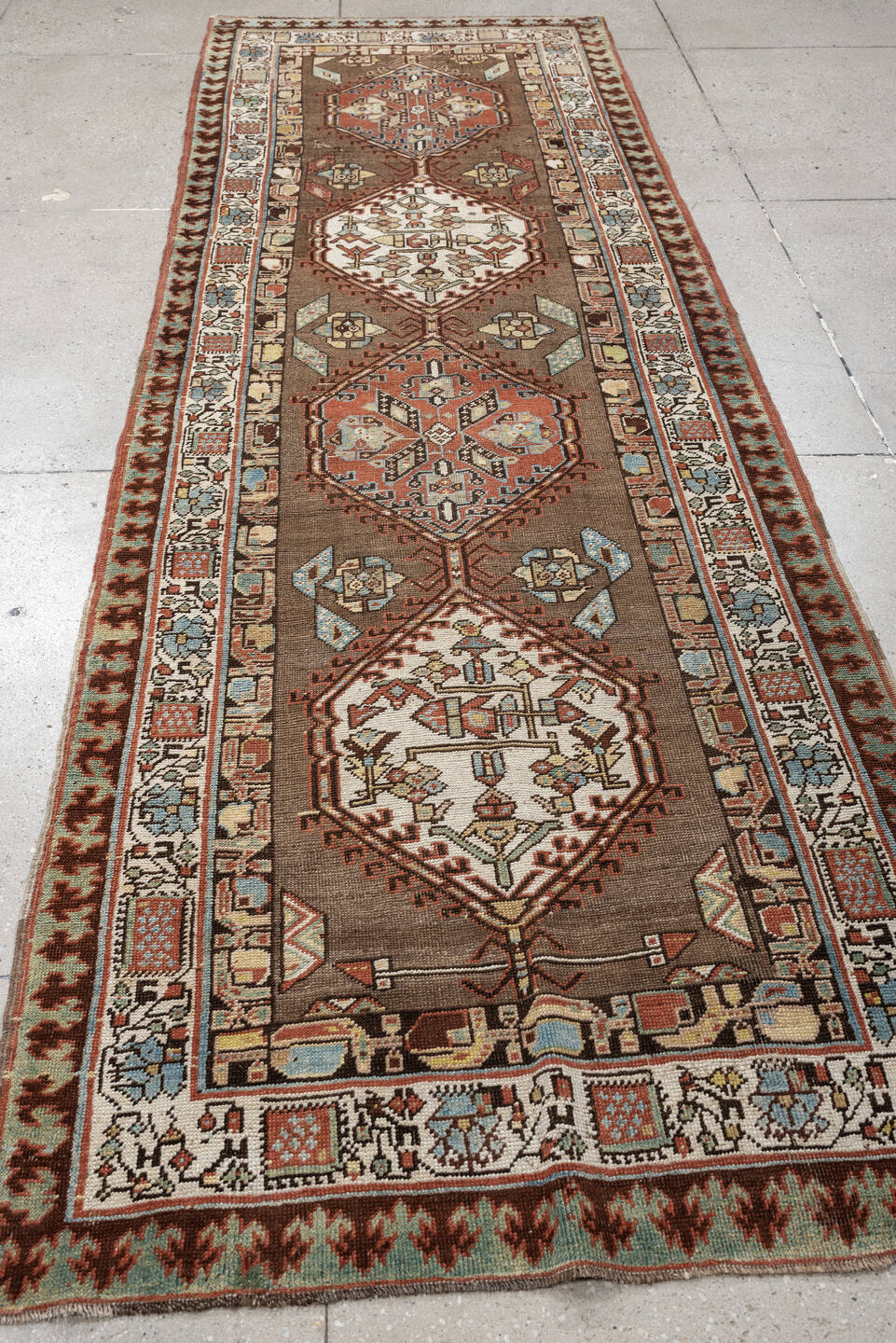 3' x 11' one-of-a-kind handmade antique Sarab runner rug. Color palette: brown, ivory, rust, sky blue, camel, terra cotta