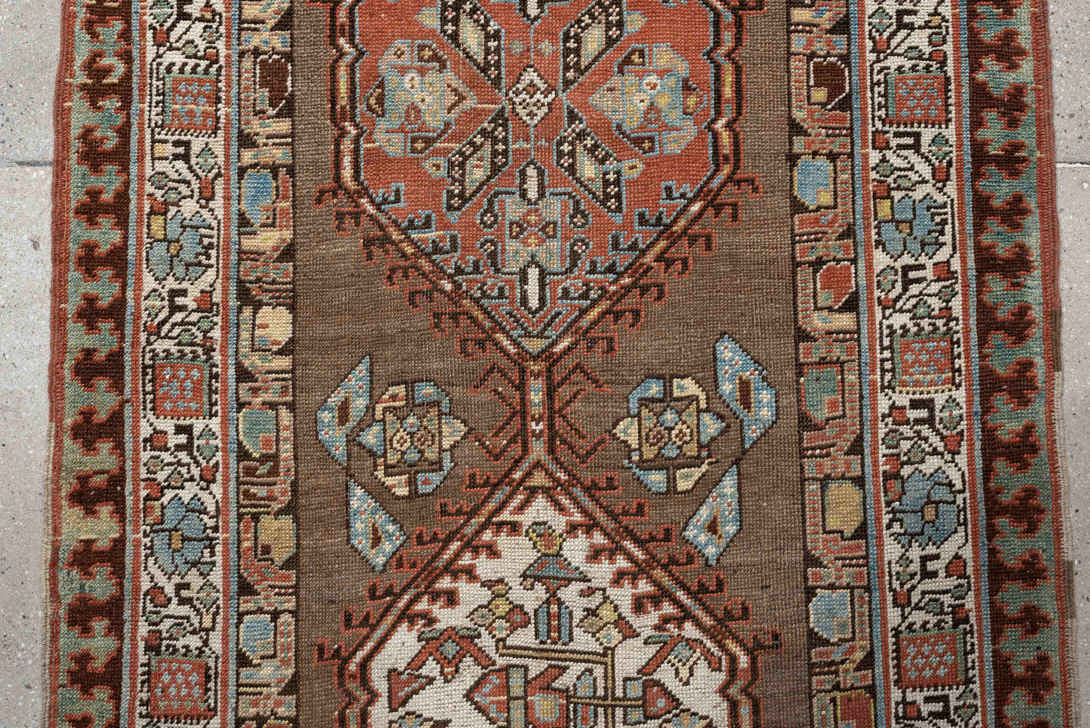 3' x 11' one-of-a-kind handmade antique Sarab runner rug. Color palette: brown, ivory, rust, sky blue, camel, terra cotta