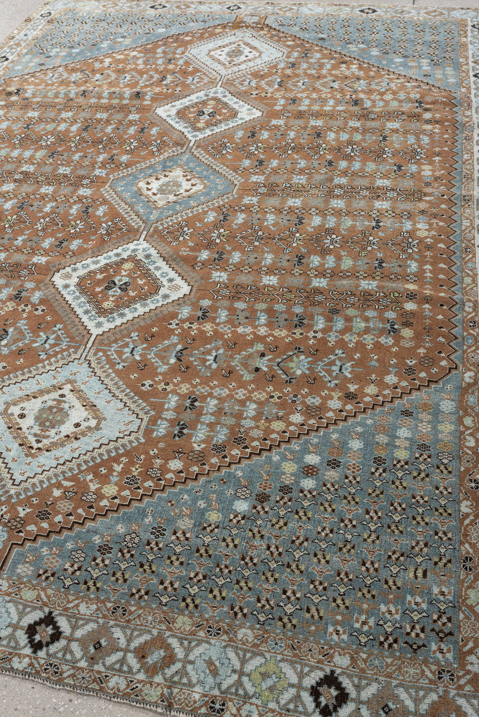 6' x 9' one-of-a-kind handmade antique Shiraz rug. Color palette: terra cotta, sky blue, ivory, camel, charcoal, sage, taupe