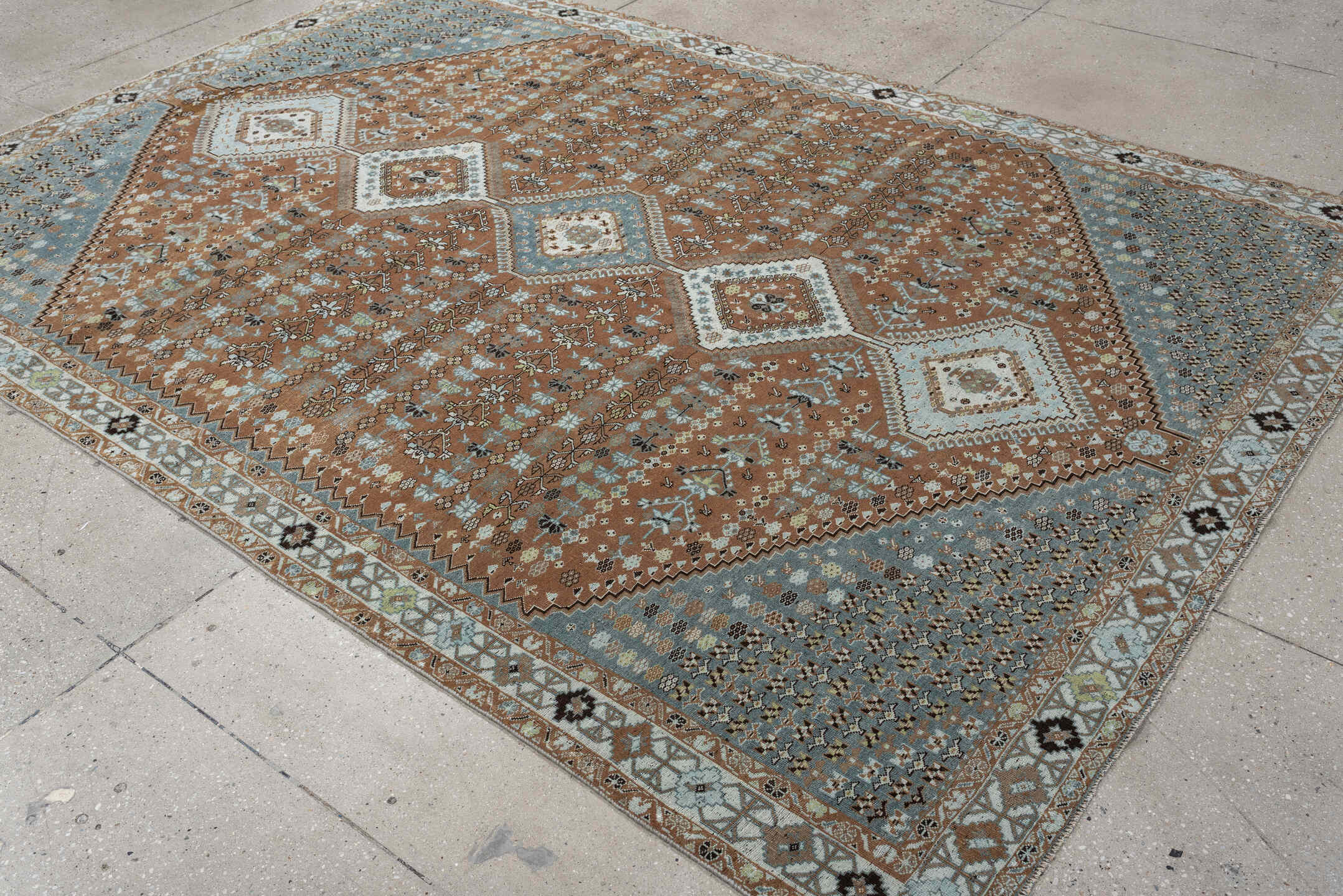 6' x 9' one-of-a-kind handmade antique Shiraz rug. Color palette: terra cotta, sky blue, ivory, camel, charcoal, sage, taupe