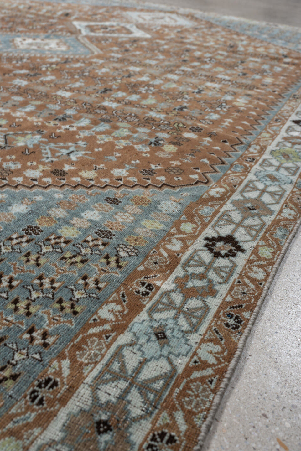 6' x 9' one-of-a-kind handmade antique Shiraz rug. Color palette: terra cotta, sky blue, ivory, camel, charcoal, sage, taupe