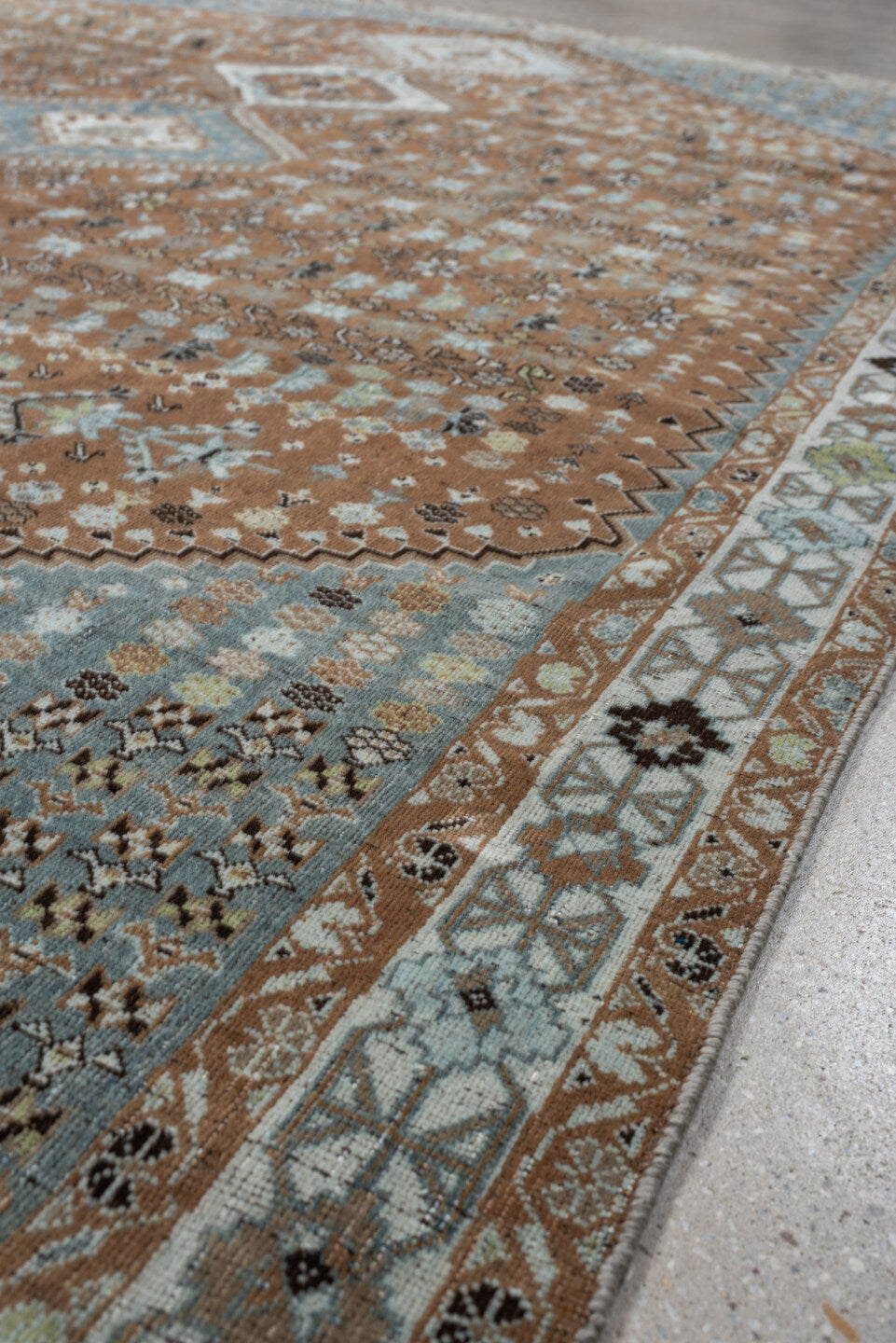 6' x 9' one-of-a-kind handmade antique Shiraz rug. Color palette: terra cotta, sky blue, ivory, camel, charcoal, sage, taupe