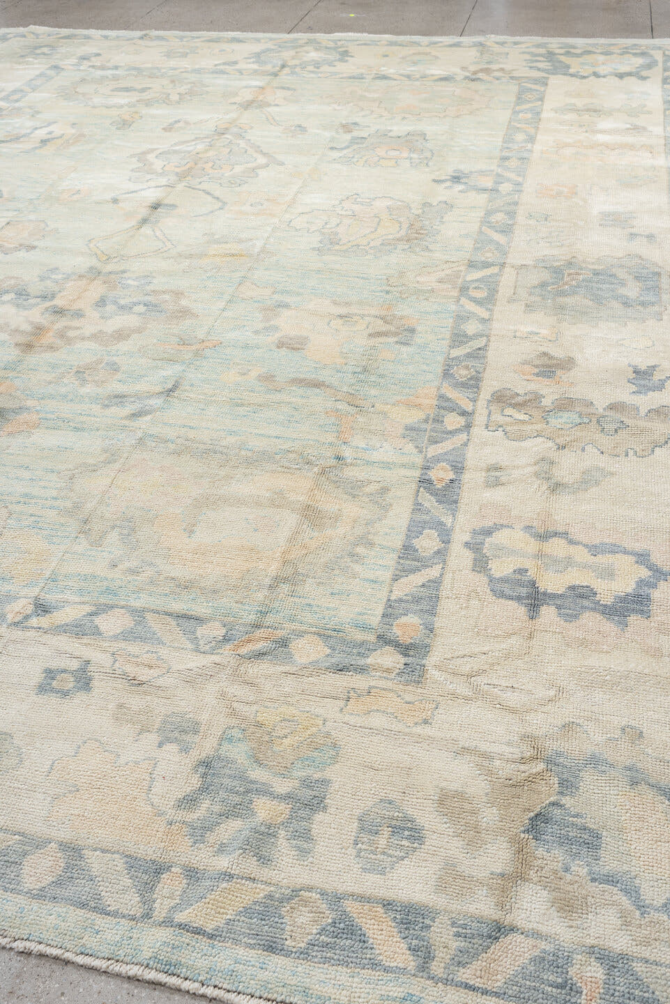 12' x 15' one-of-a-kind handmade vintage Oushak oversize rug. Color palette: ivory, pale blue, sky blue, taupe, beige, sage