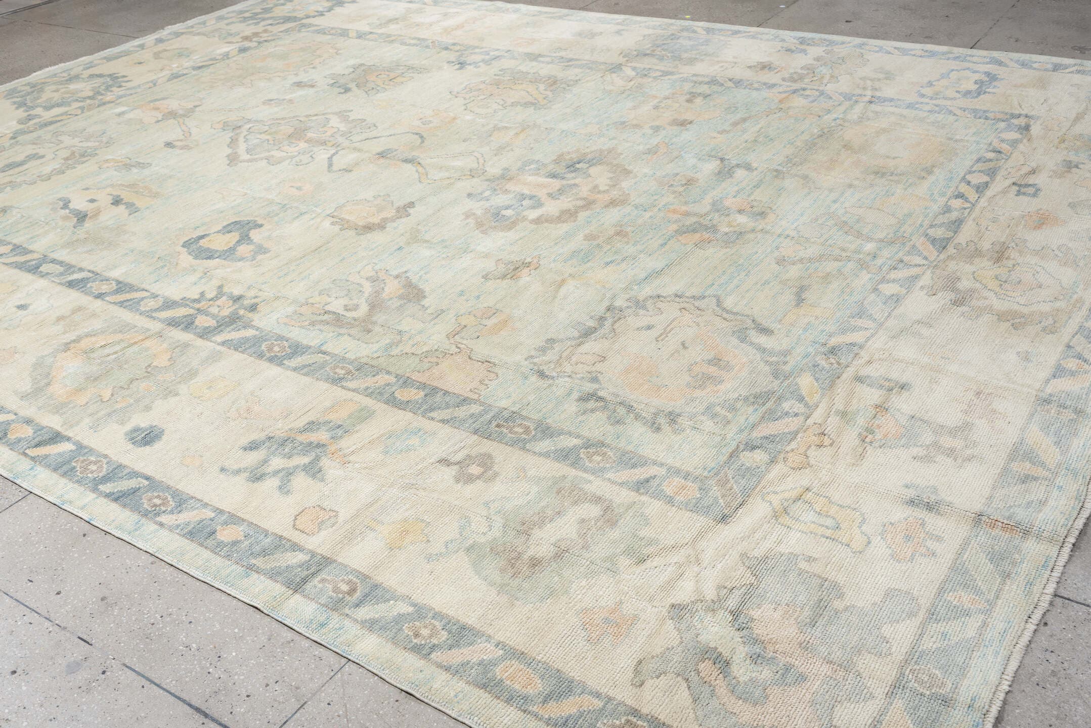 12' x 15' one-of-a-kind handmade vintage Oushak oversize rug. Color palette: ivory, pale blue, sky blue, taupe, beige, sage