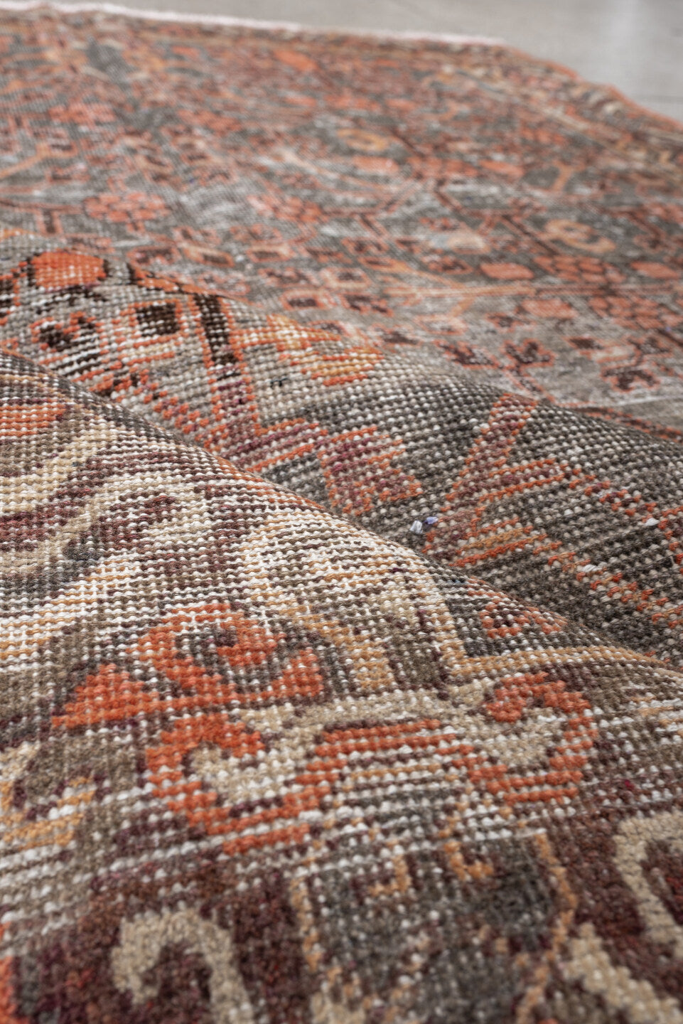 4' x 7' one-of-a-kind handmade antique  rug. Color palette: charcoal, coral, ivory, taupe, slate, terra cotta, brown, black
