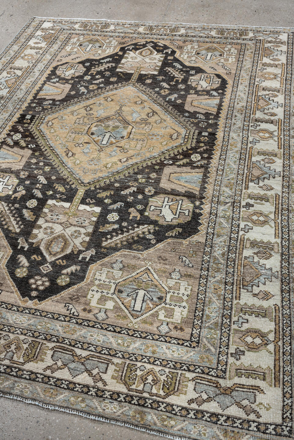 4' x 6' one-of-a-kind handmade antique Shiraz rug. Color palette: ivory, charcoal, camel, taupe, pale blue, olive, sand