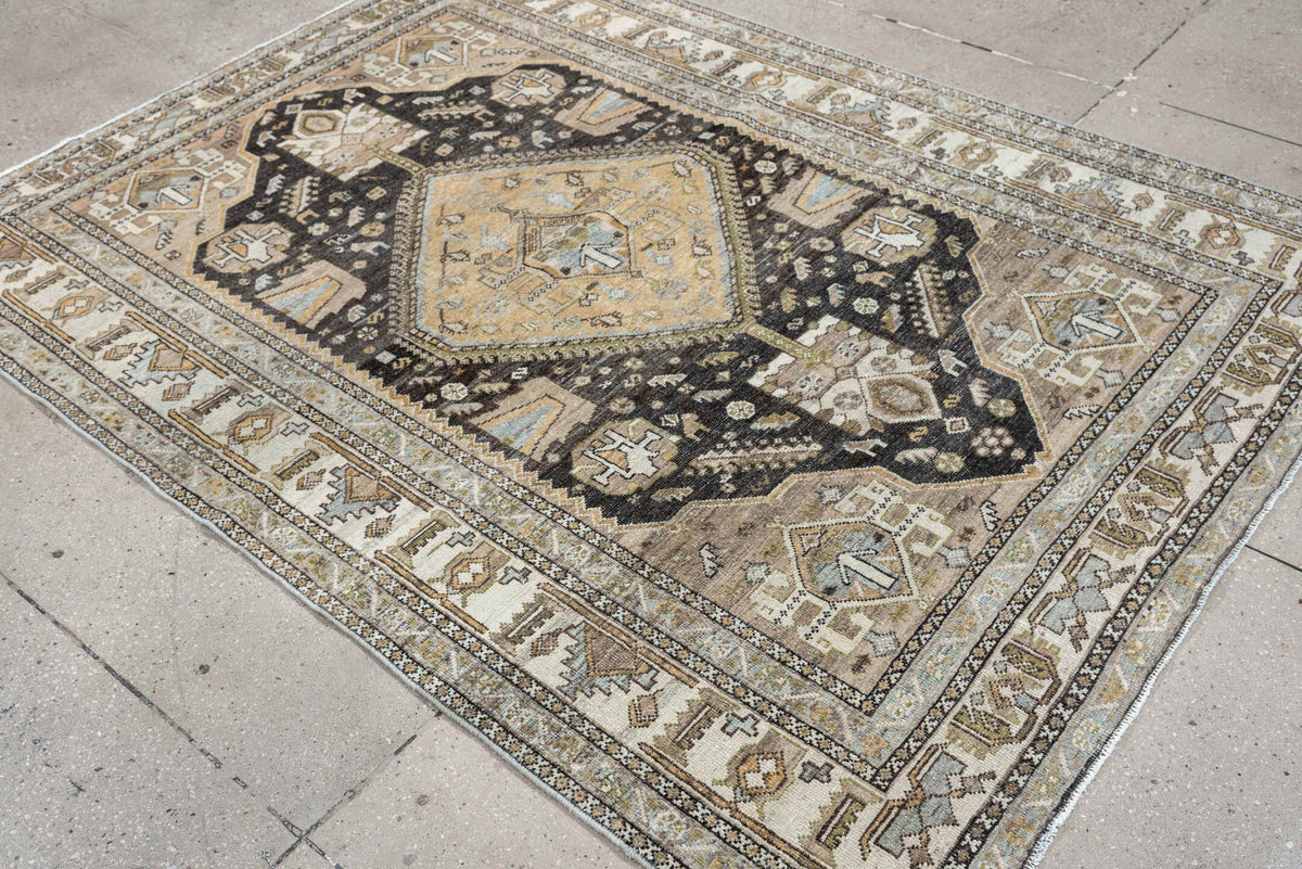 4' x 6' one-of-a-kind handmade antique Shiraz rug. Color palette: ivory, charcoal, camel, taupe, pale blue, olive, sand