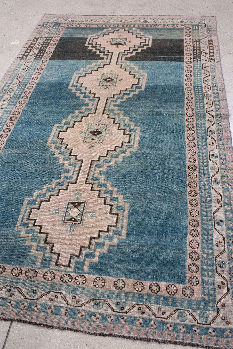 4' x 7' one-of-a-kind handmade antique Shiraz rug. Color palette: teal blue, ivory, blush, charcoal, slate blue, dark brown