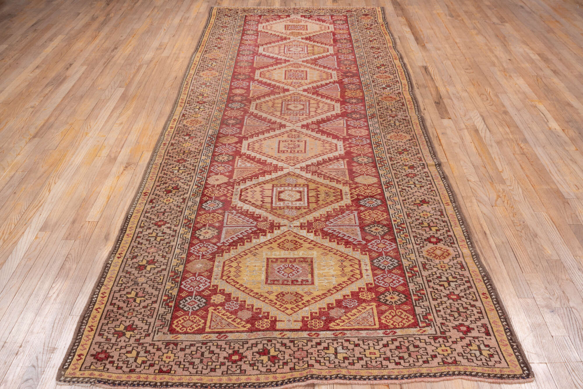 4' x 11' one-of-a-kind handmade vintage Kurd runner rug. Color palette: brown, pink, red