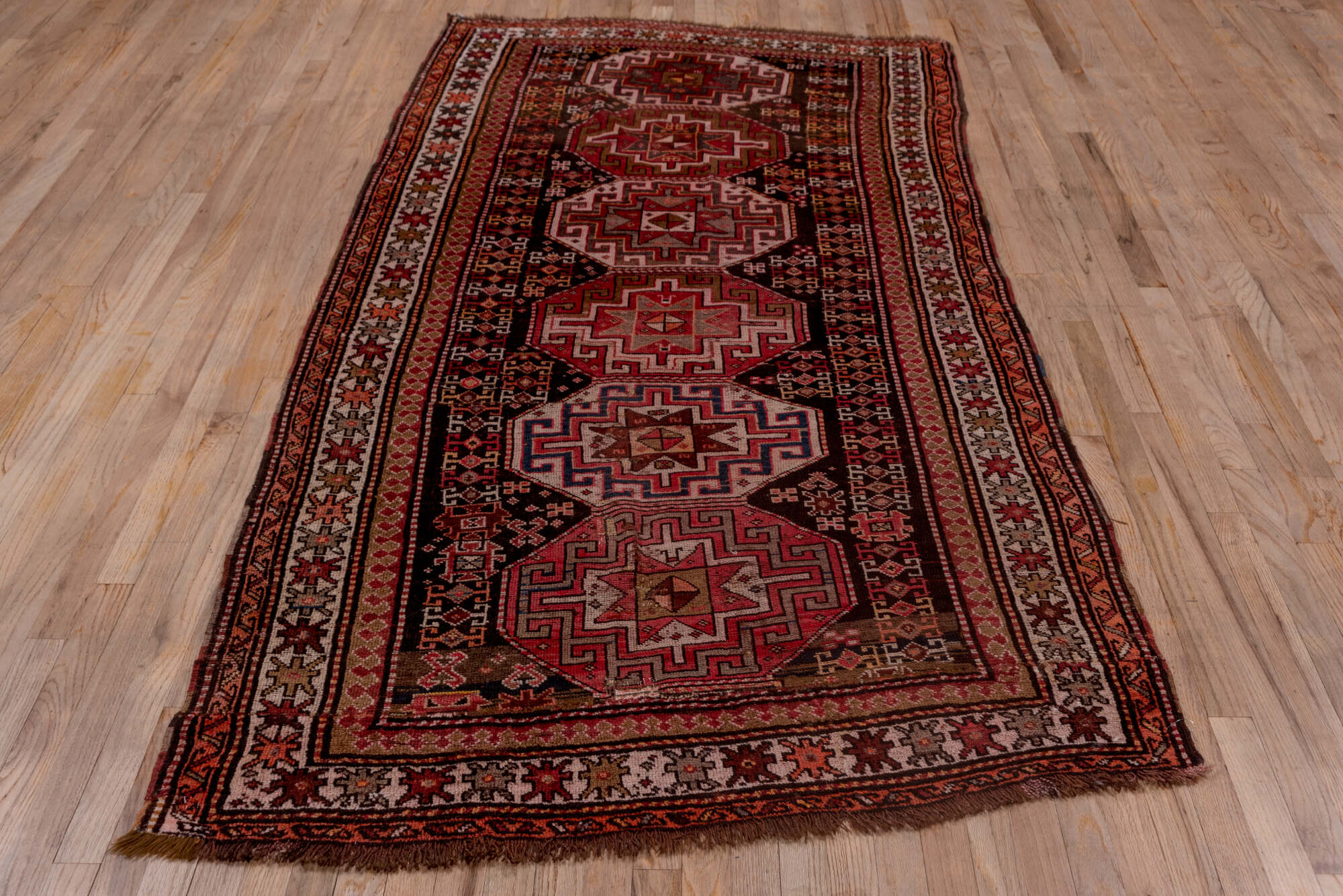4' x 9' one-of-a-kind handmade vintage Kazak runner rug. Color palette: brown, gray, pink, red, rosy brown